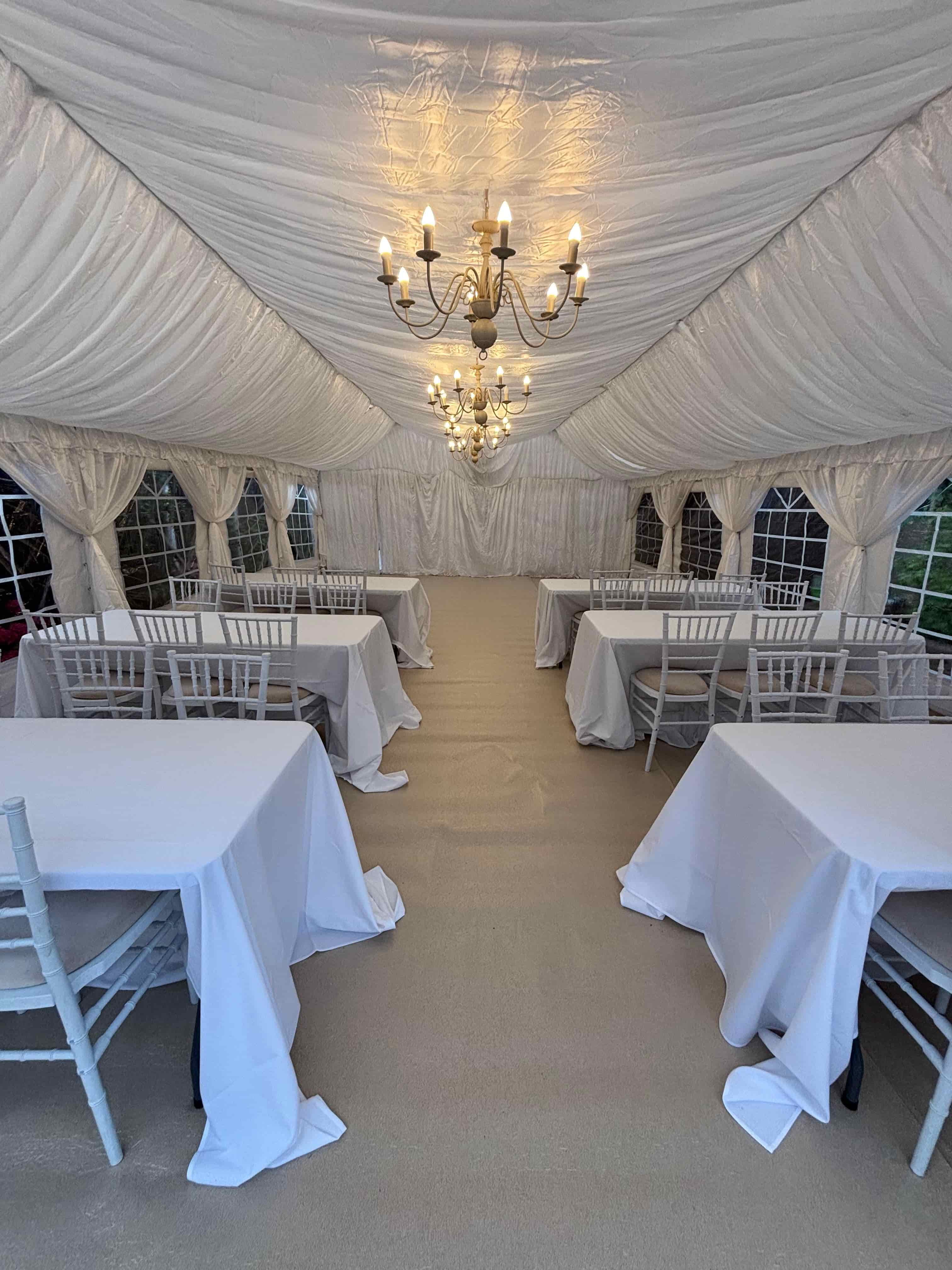 Wedding reception marquee interior with chandeliers and dressed dining tables